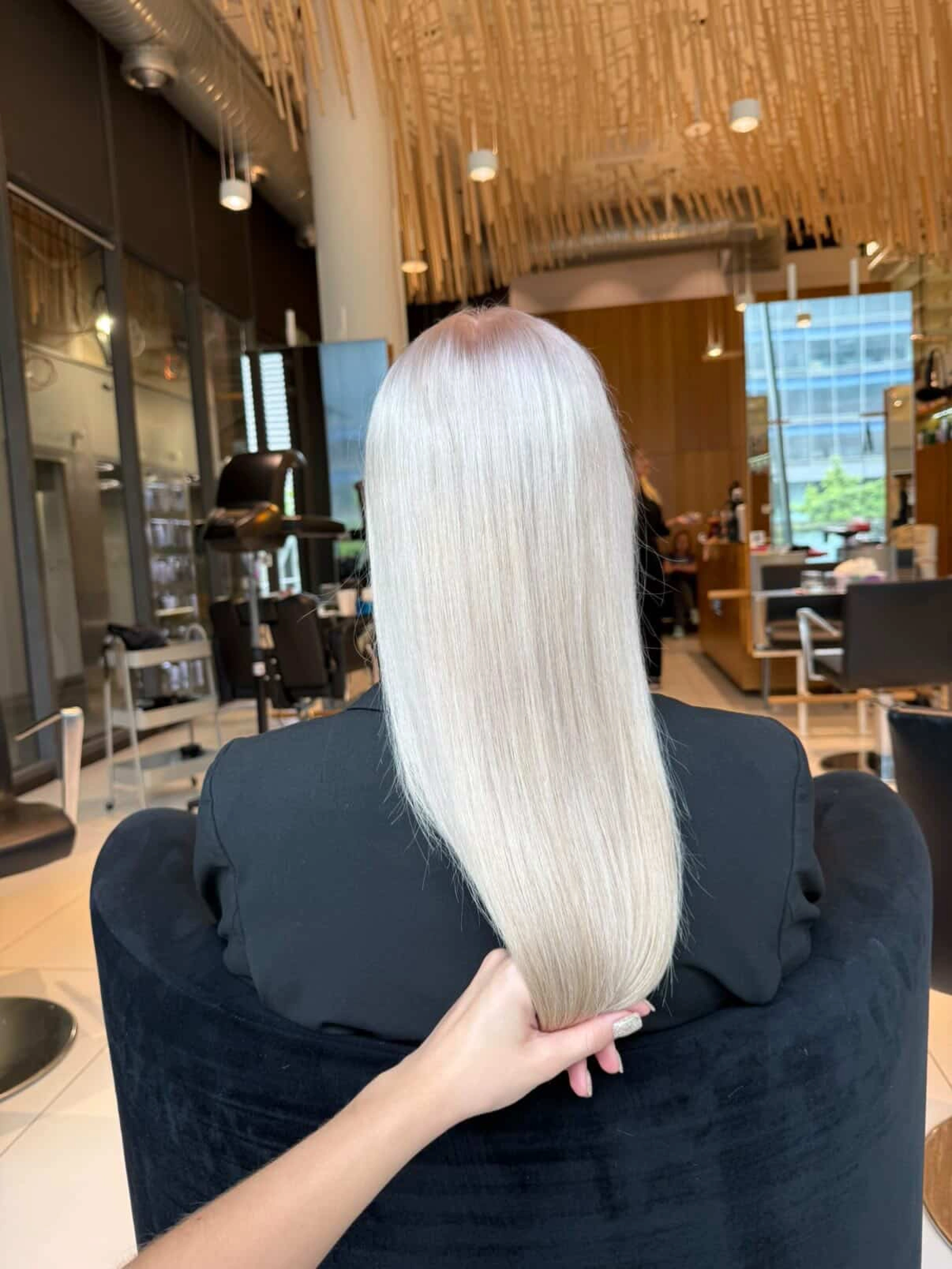 Dokonale rovné platinové blond vlasy zobrazené zezadu.
