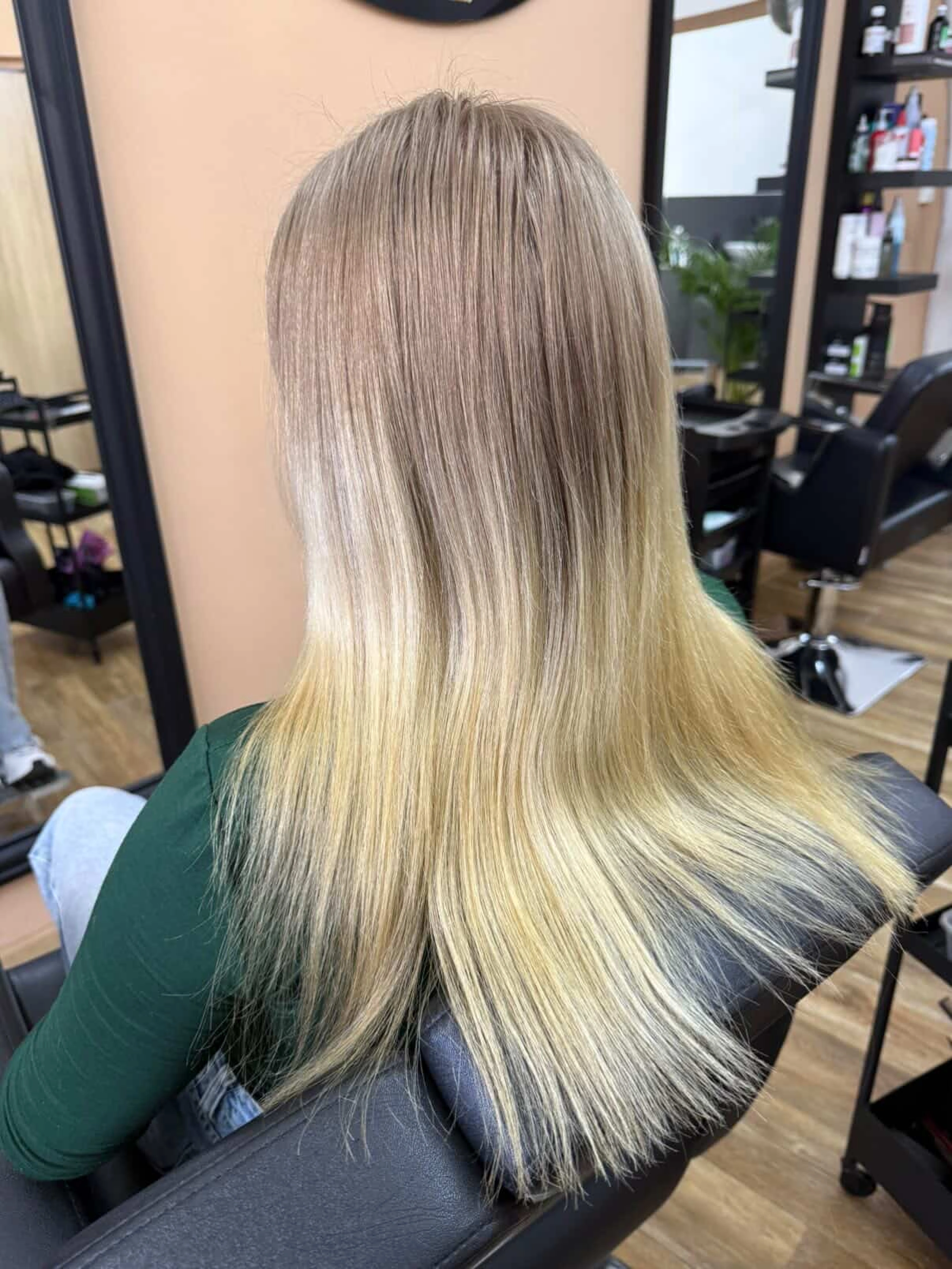 Blond balayage s přechodem na dlouhých rovných vlasech.