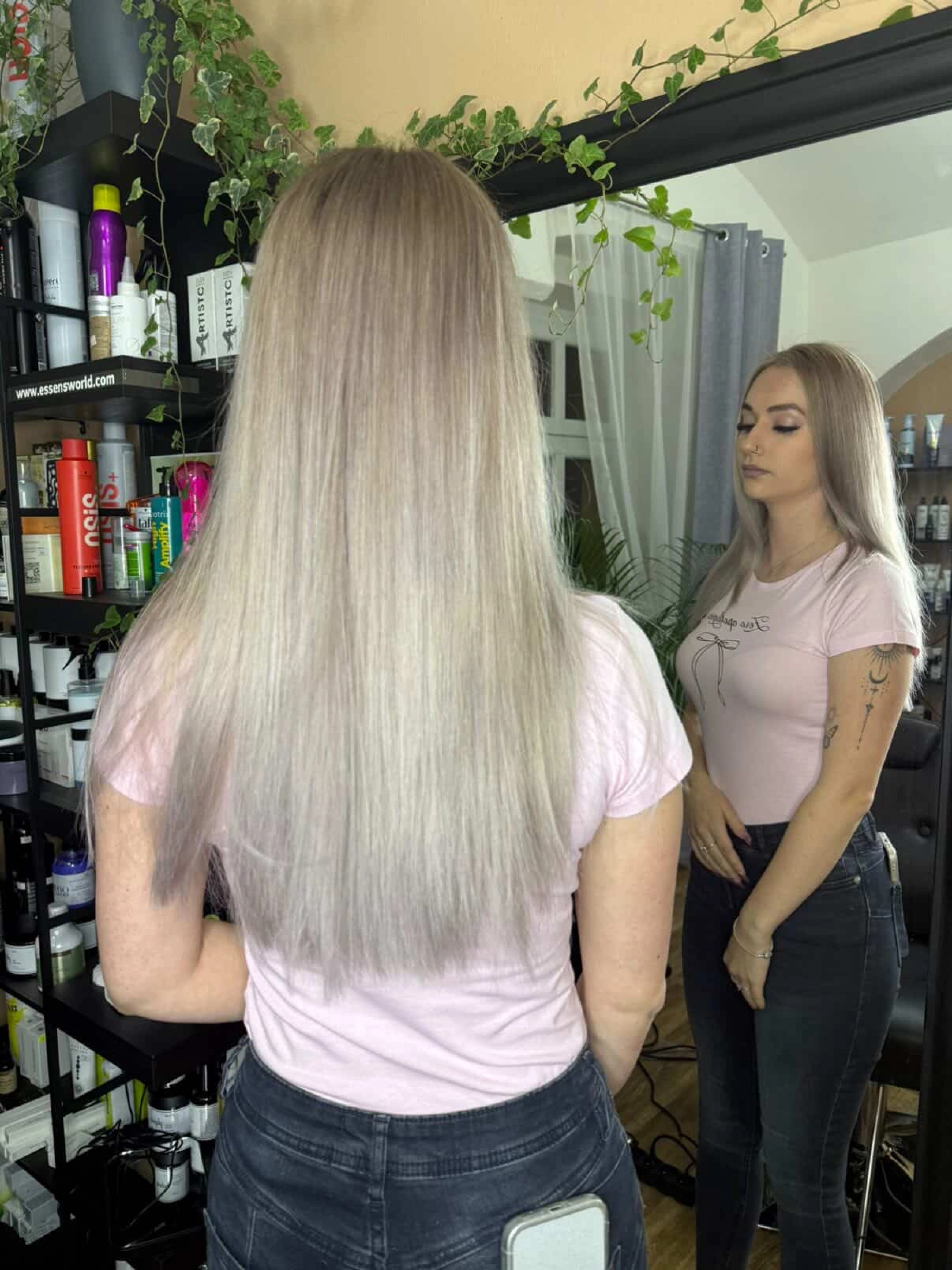 Dlouhé popelavě blond vlasy s odrazem v zrcadle.